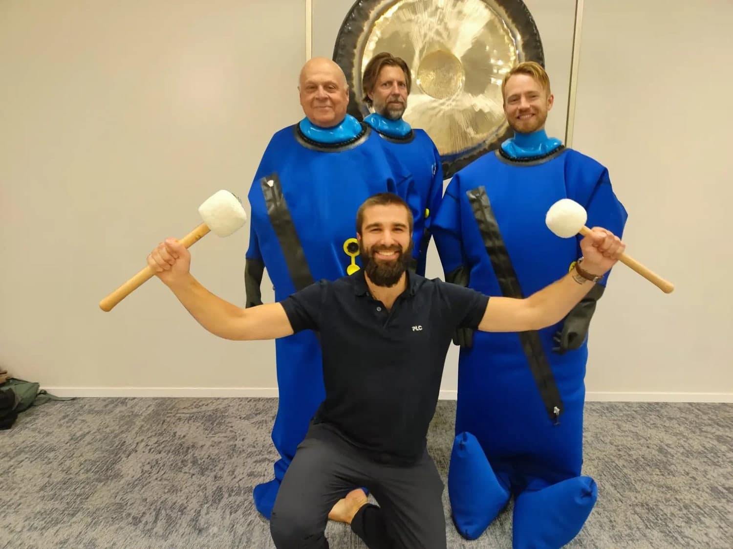 A group of people wearing blue BodyStream CO2 therapy suits together during a wellness session